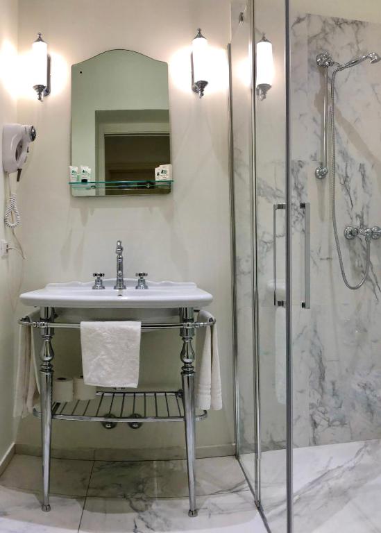 a bathroom with a sink and a shower at Hotel Du Parc in Stresa