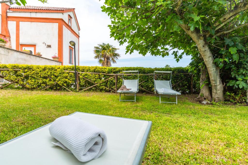 a bed and two chairs in a yard at La TERRAZZA sul GIARDINO in Procida