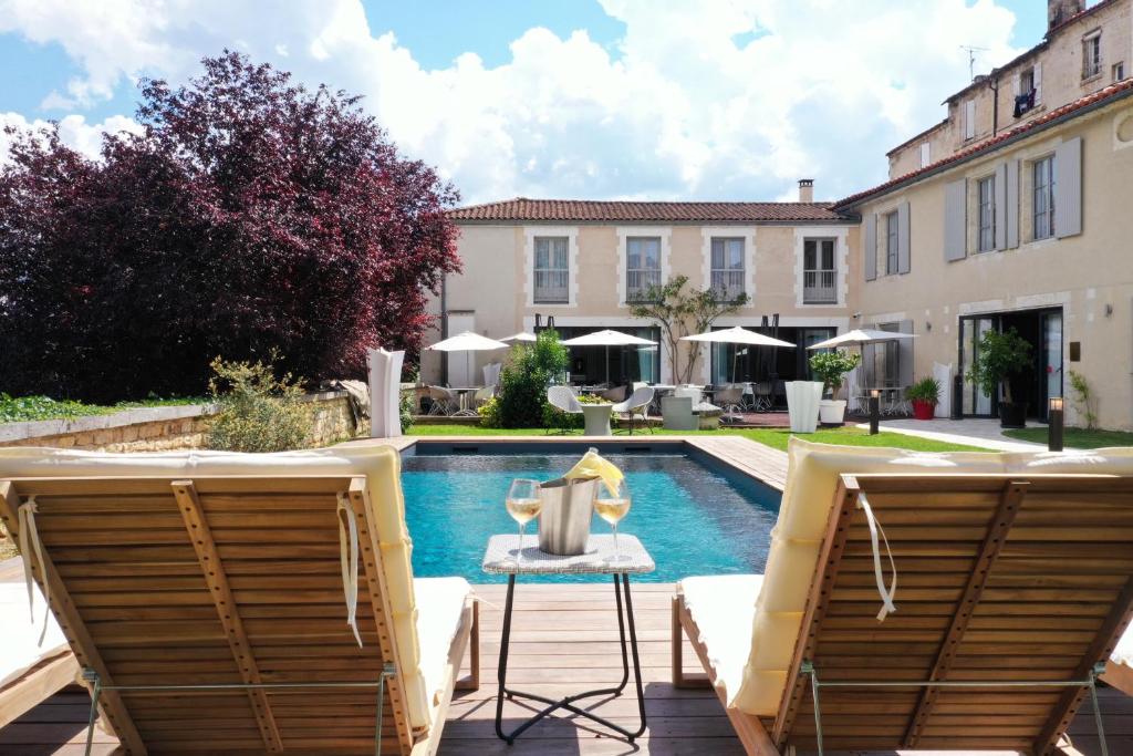 a patio with two chairs and a swimming pool at Hotel Le Saint Gelais in Angoulême