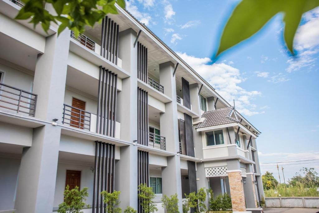 um edifício de apartamentos com colunas brancas e janelas em Siya House Hotel em Chiang Rai