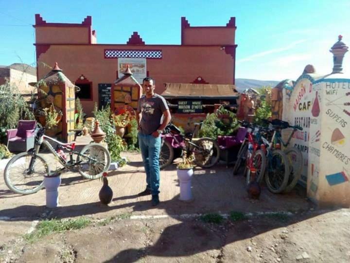 Ein Mann steht vor einem Laden mit Fahrrädern. in der Unterkunft Maison d'hôtes La vallée des nomades in Semrir