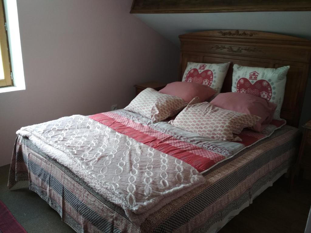 ein Bett mit rosa und weißen Decken und Kissen in der Unterkunft Daphrose chambre in Lachau
