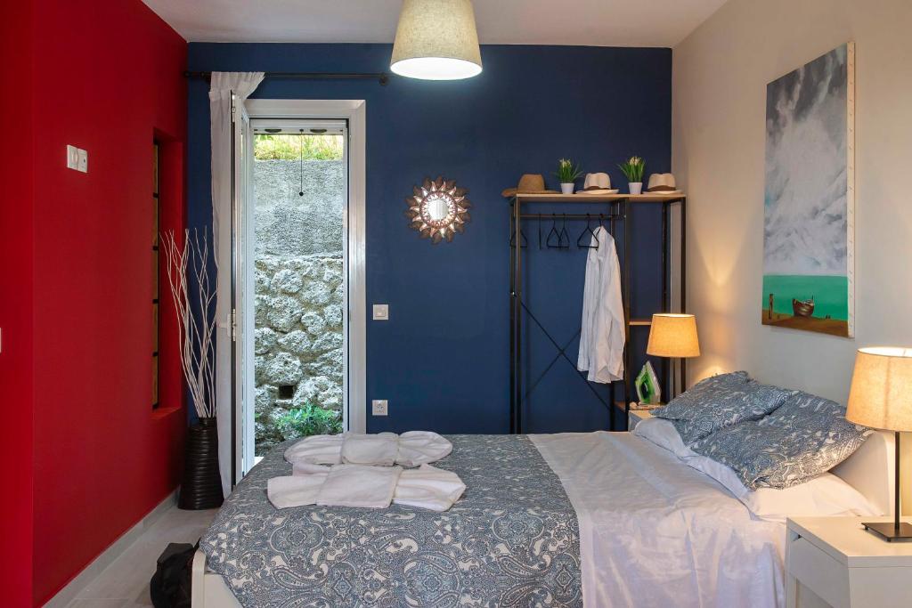 um quarto com uma cama e uma parede vermelha e azul em Ammos Beach House em Glyfada