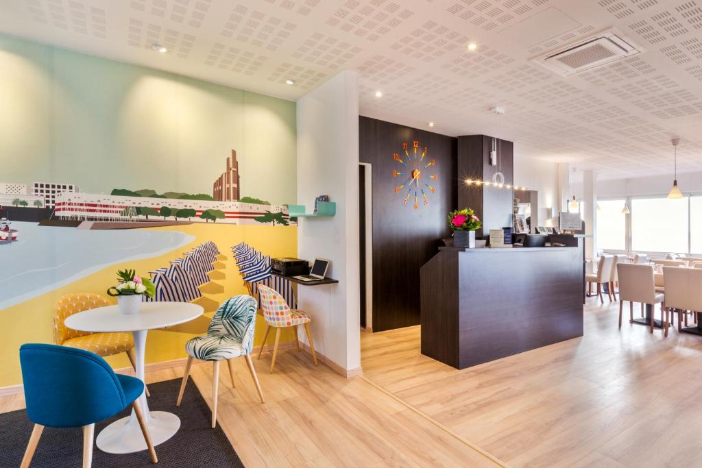 a restaurant with chairs and a table and a counter at Best Western Hôtel Royan Océan in Royan