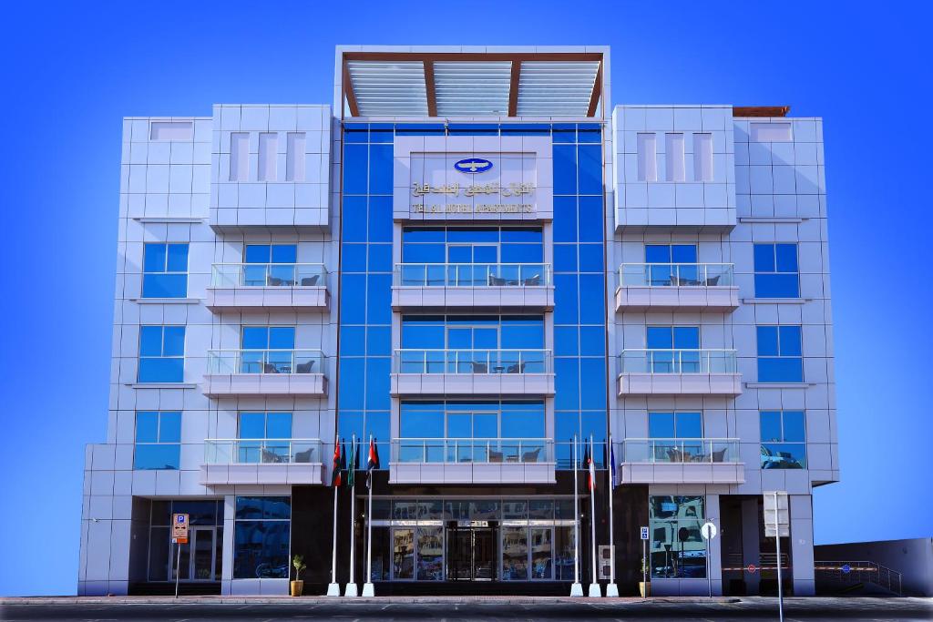 Un edificio azul con un cartel. en Telal Hotel Apartments en Dubái