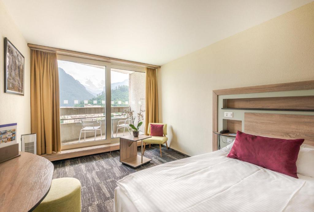 Postel nebo postele na pokoji v ubytování Hotel Metropole Interlaken