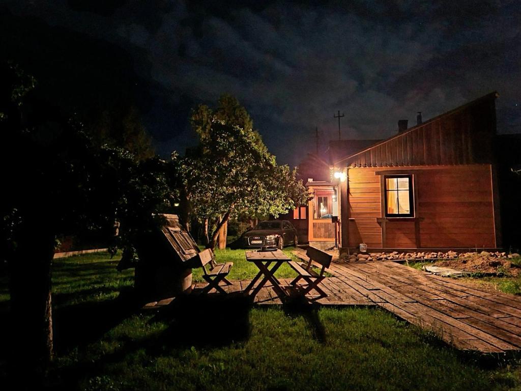 a picnic table and two chairs in a yard at night at Dom Dziadka in Janów Podlaski