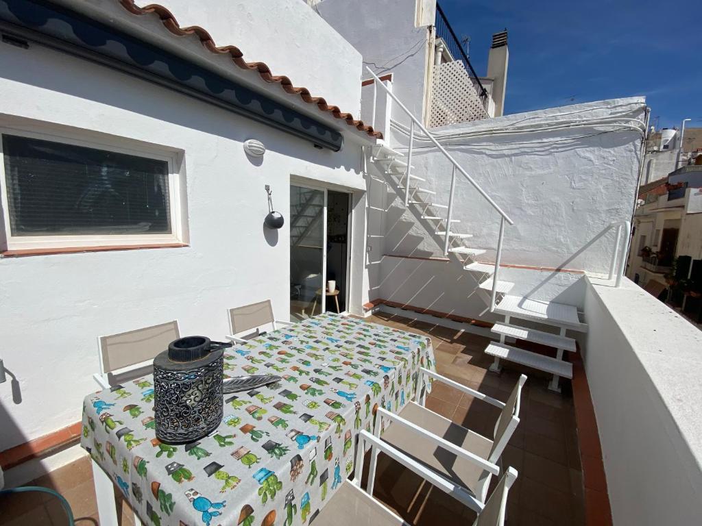 una mesa y sillas en el balcón de una casa en Amazing 2 bedroom Apartment with big sun terrace Sitges centre beach en Sitges