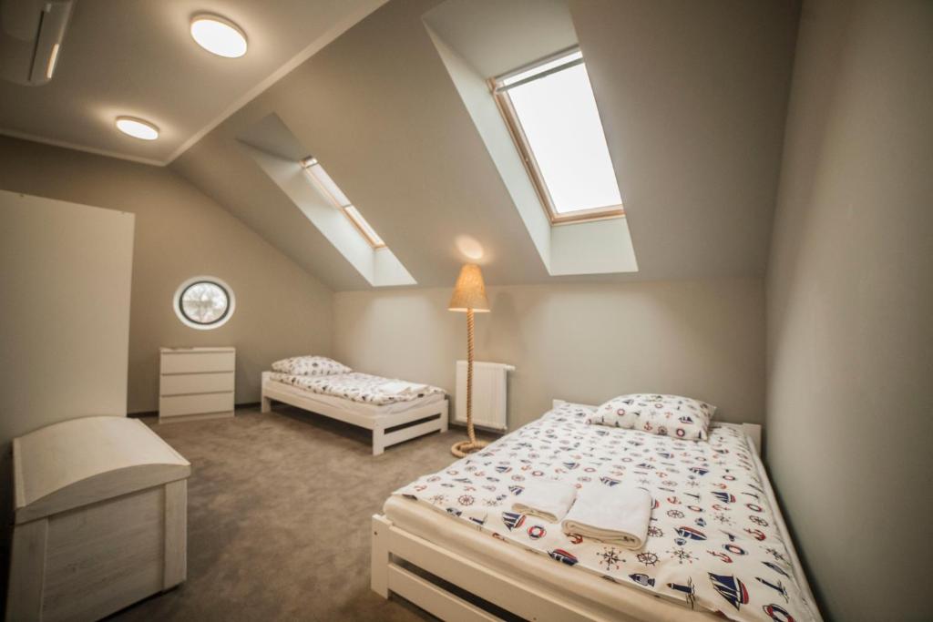 a attic bedroom with two beds and a skylight at Hostel pod Cisem in Elblag