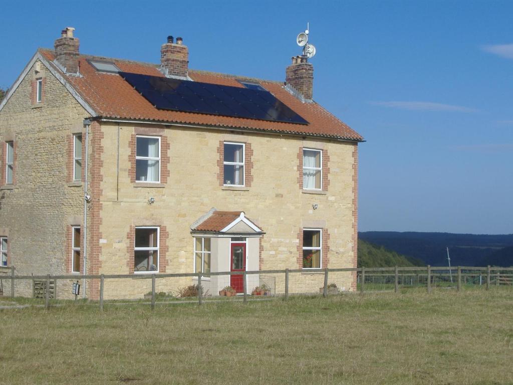 a large brick house with a red door in a field at South Moor Farm in Scarborough