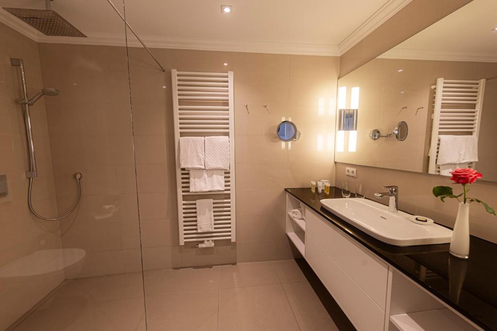 a bathroom with a sink and a shower at Strandhotel Fontana in Timmendorfer Strand