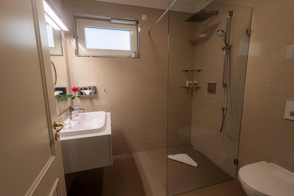a bathroom with a shower and a sink and a toilet at Strandhotel Fontana in Timmendorfer Strand