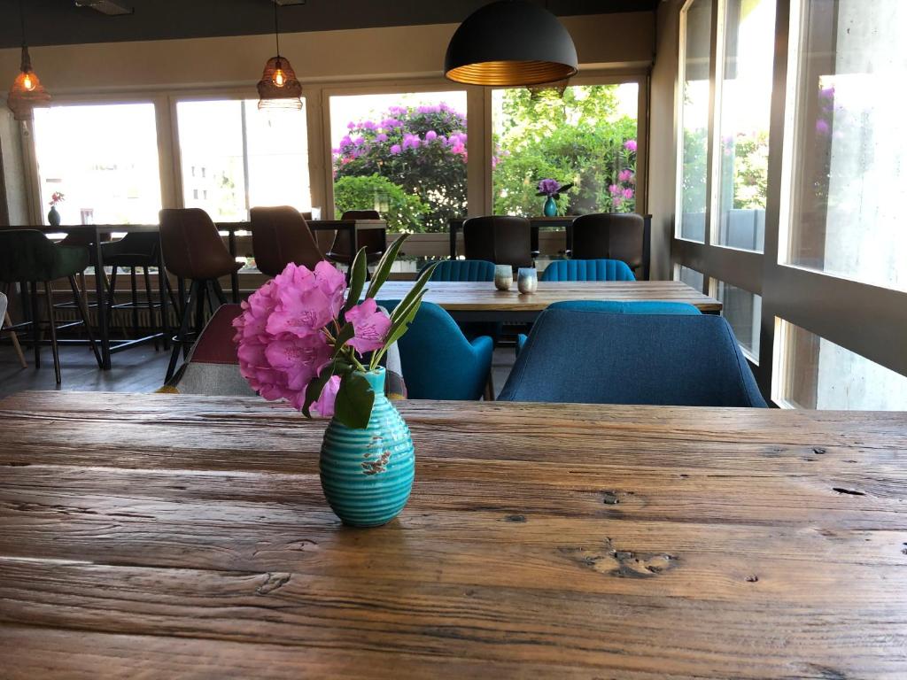 eine Vase rosafarbener Blumen auf einem Holztisch in der Unterkunft Boutique Hotel Kronenhof in Zürich