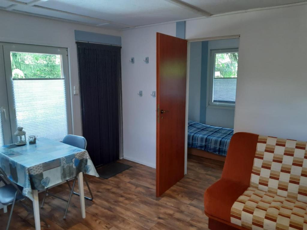 een woonkamer met een tafel en een bed bij LUNA nad jeziorem Wojnówko gm Murowana Goślina in Wojnówko