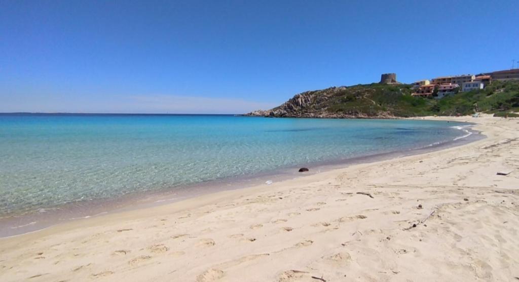 een strand met zand en de oceaan en huizen bij Stella Guest House in Santa Teresa Gallura