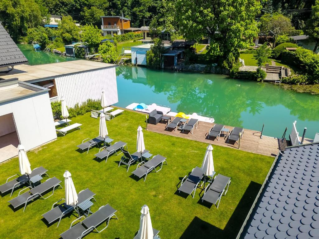 uma vista superior para uma piscina com cadeiras e guarda-sóis em Hotel Rösch em Klagenfurt