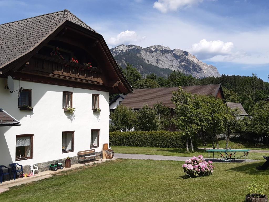 a large white building with a picnic table and a mountain at Ferienwohnung Johanna in Sankt Georgen im Gailtal