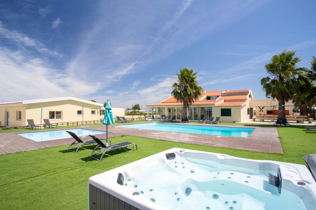 una bañera de hidromasaje en el patio de una casa en 10 bedrooms villa with private pool enclosed garden and wifi at Palmela en Palmela