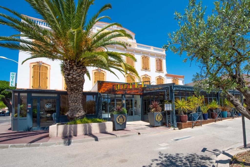 un palmier devant un bâtiment dans l'établissement Hotel Restaurant La Villa Arena, à Carry-le-Rouet