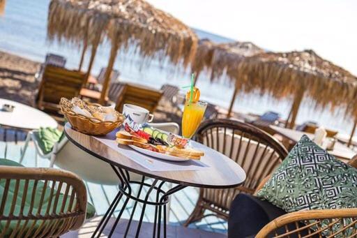 a table with a plate of food and a drink at Aquarius Beach Hotel in Faliraki