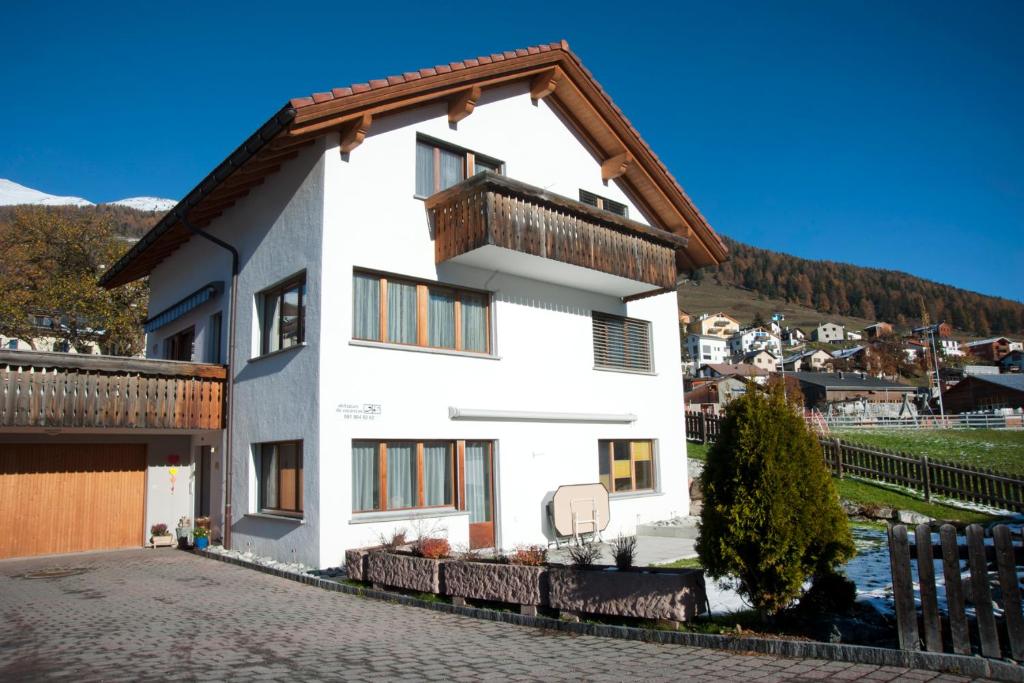 una casa bianca con tetto in legno di Wieser - Ferienwohnung für 2-3 Personen a Sent