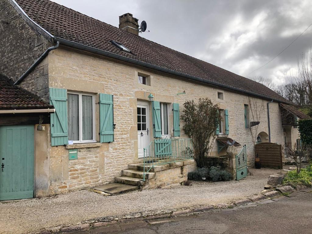 ein altes Backsteinhaus mit grünen Rollläden und Treppen in der Unterkunft Les Belles Fontaines in Bierry-les-Belles-Fontaines