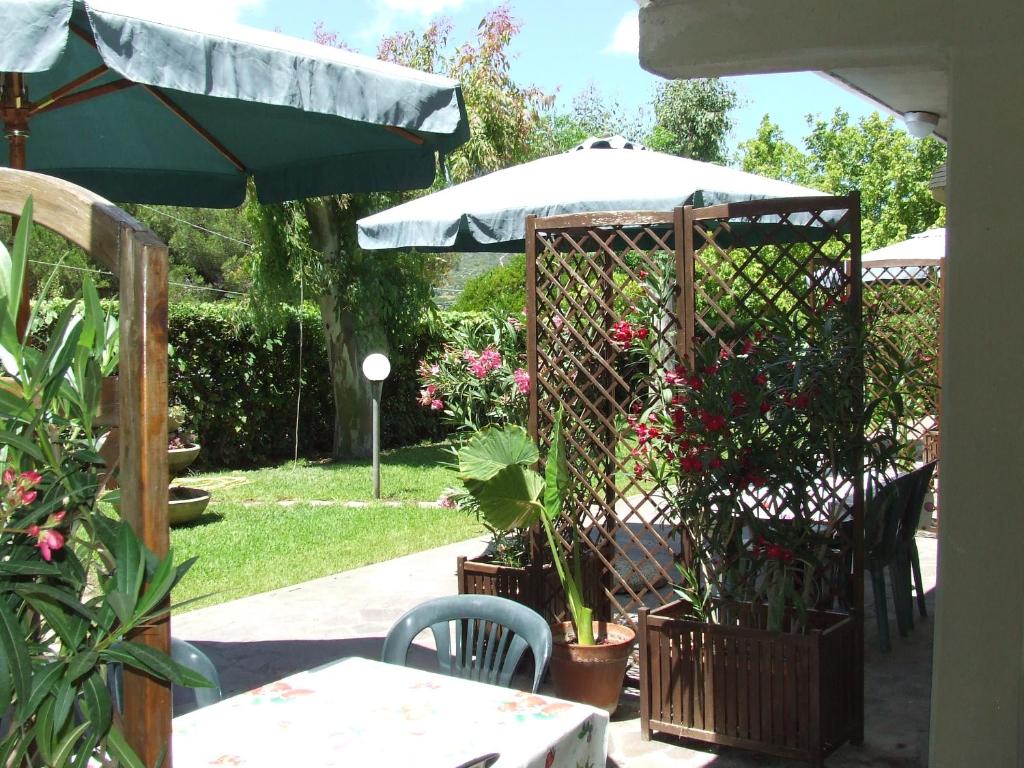patio con ombrellone e alcune piante e tavolo di Casa Vacanze Lentisco by HelloElba a Marina di Campo
