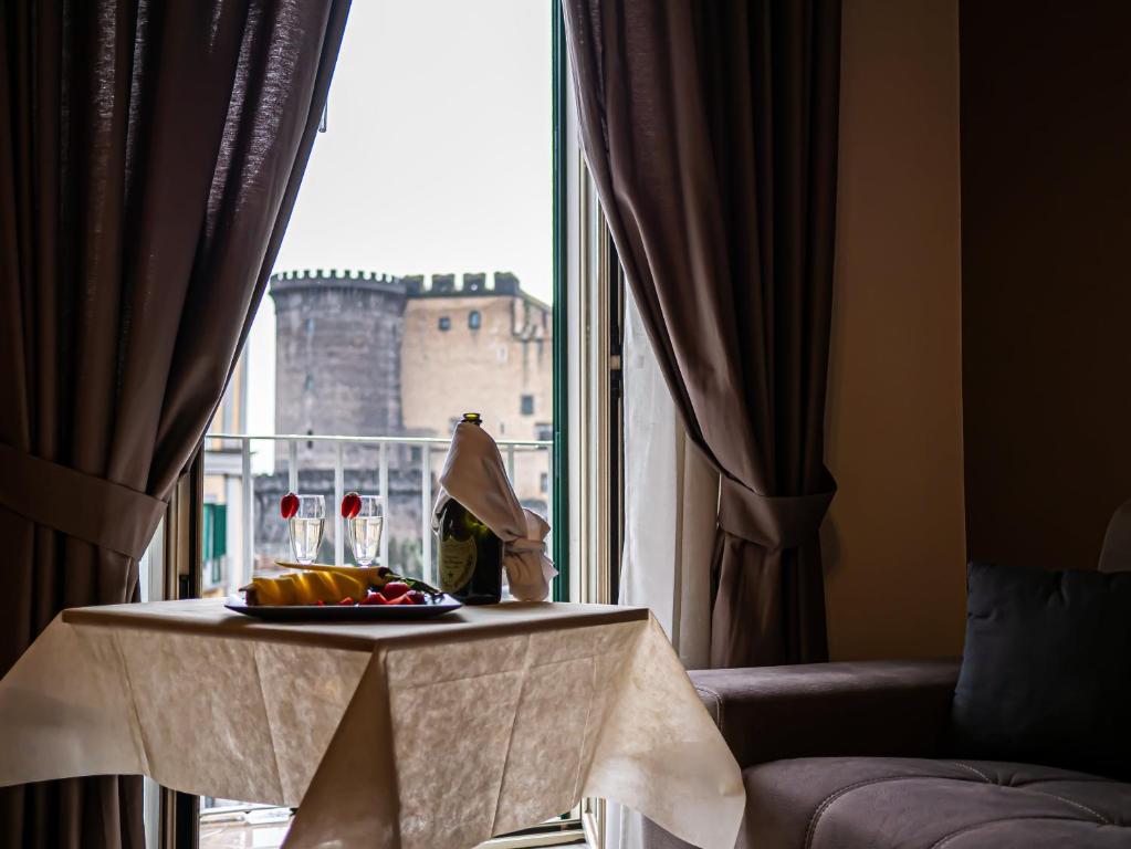 a table with a plate of food in front of a window at San Marco Hotel in Naples