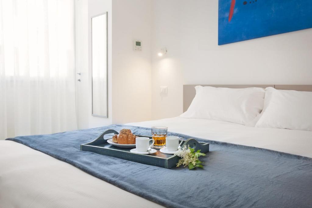 a tray with food and drinks on a bed at LA ROCCA SUITE in Garda