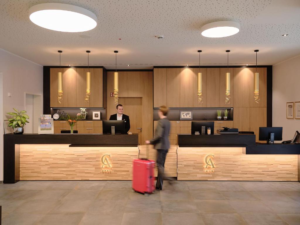 a person with a red suitcase standing in a lobby at Hotel Restaurant Clemens-August in Ascheberg