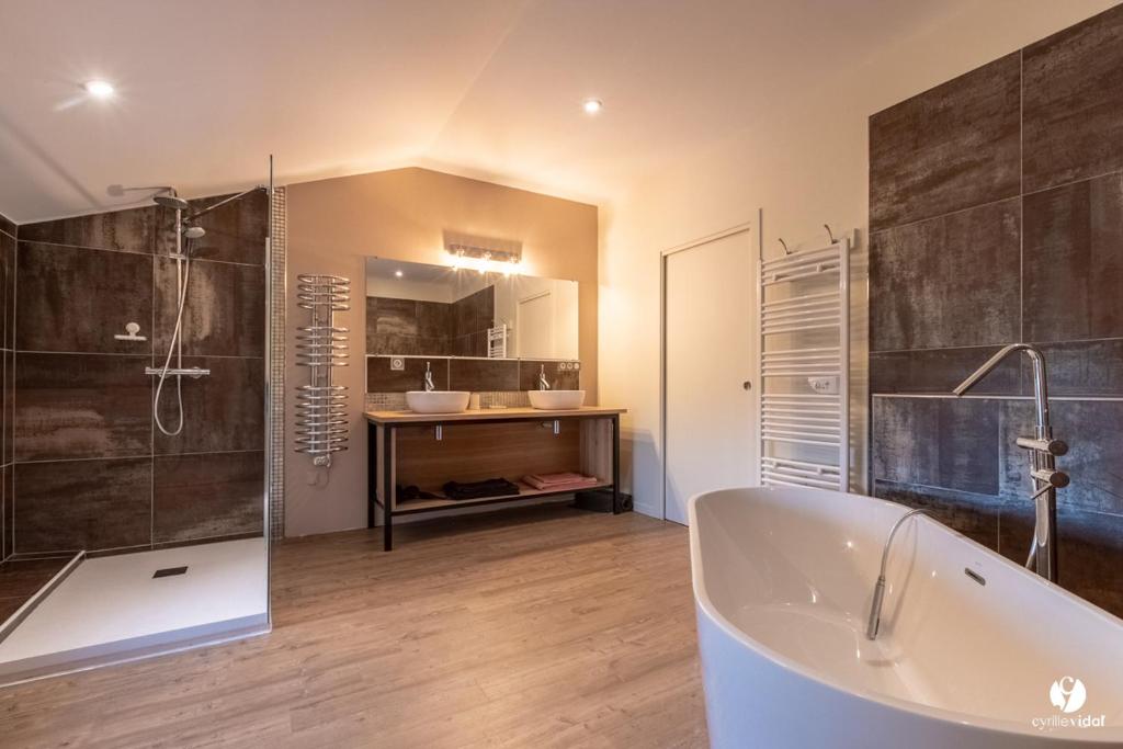 a large bathroom with a tub and a shower at Othil in Aire-sur-lʼAdour