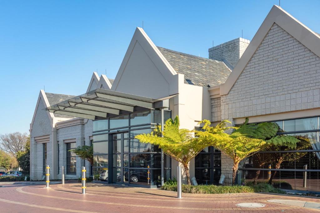 肯普頓公園的住宿－City Lodge Hotel Johannesburg Airport, Barbara Road，前面有棕榈树的建筑