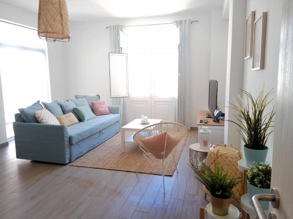 uma sala de estar com um sofá azul e uma mesa em ALMA Flat in Olhão em Olhão