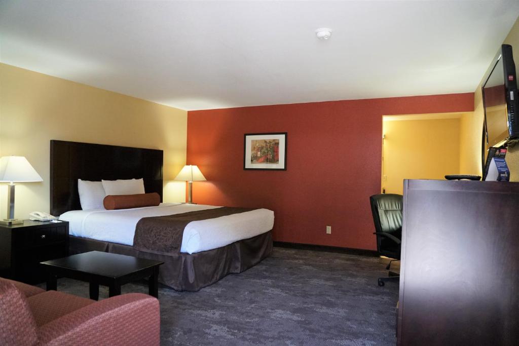 ein Hotelzimmer mit einem Bett und einem Stuhl in der Unterkunft McMinnville Inn in McMinnville