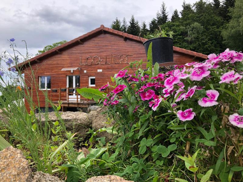 une maison avec une pancarte avec des fleurs roses dans l'établissement Maison avec piscine couverte Pilat Ardèche, à Saint-Sauveur-en-Rue