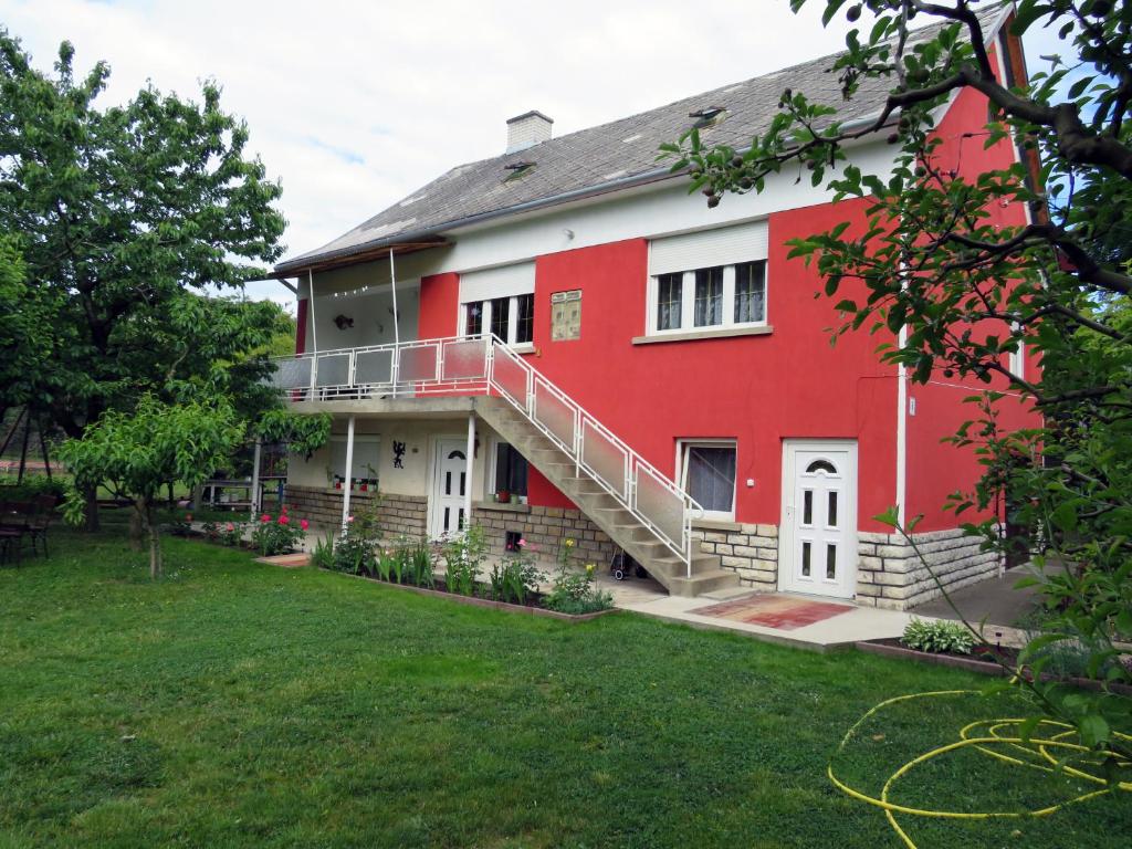a red building with a staircase in a yard at Székely Apartman in Balatonfüred
