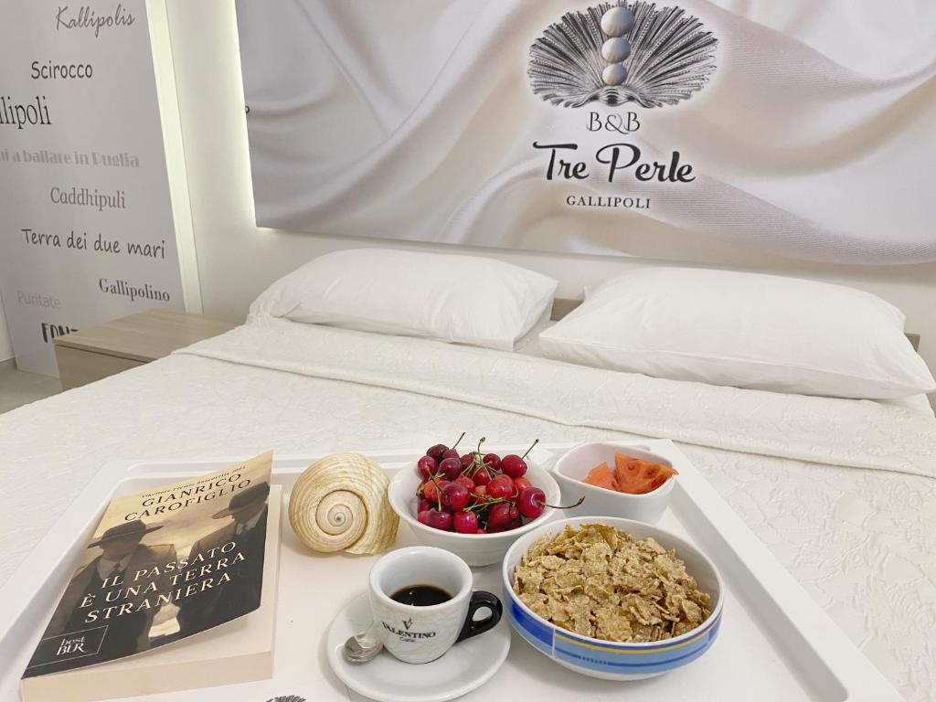 ein Tablett mit Essen auf einem Bett mit einem Teller. in der Unterkunft B&b Tre Perle in Gallipoli