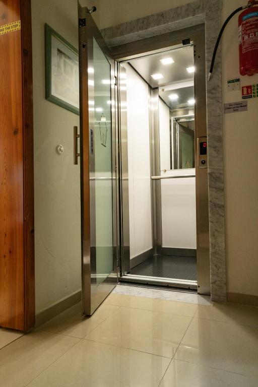 an open elevator door in a building with a glass door at Lantern Guest House in Marsalforn
