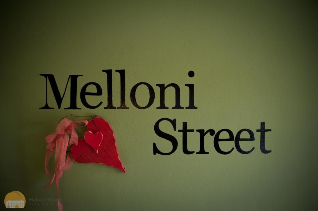 Un cartello che dice melone street con un fiore rosso di B&B MELLONI STREET a Dolo