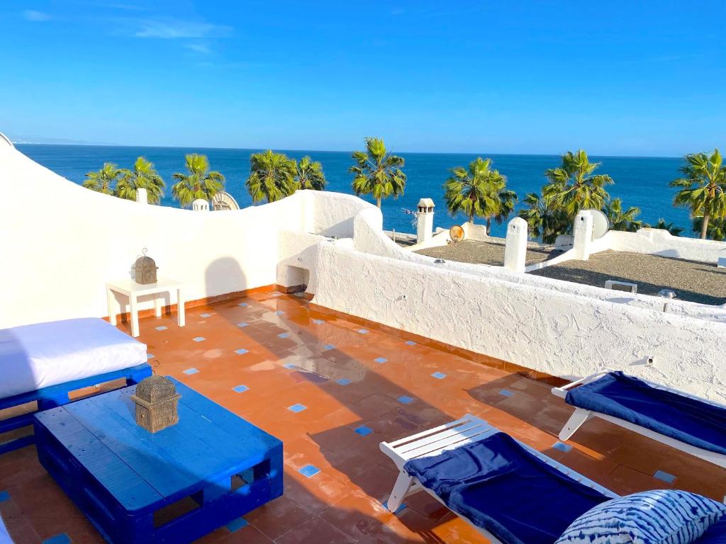 een patio met stoelen en de oceaan op de achtergrond bij PLAYA PALOMA Beach House 8PAX in Estepona