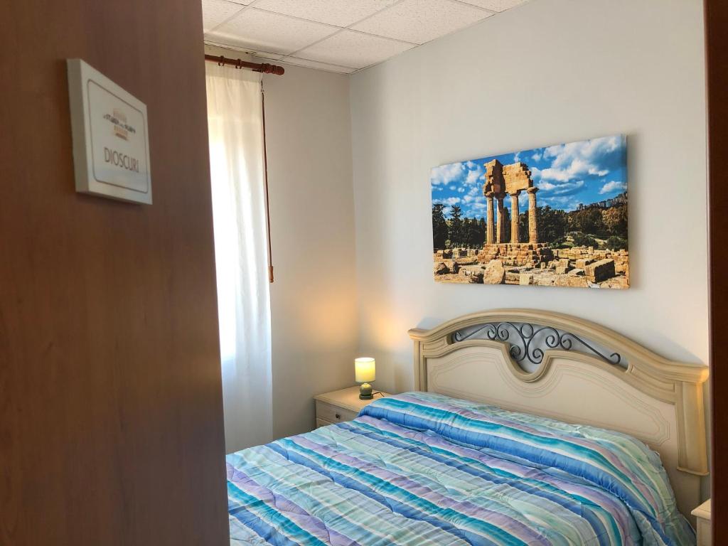 een slaapkamer met een bed met een foto aan de muur bij Le stanze dell'Olimpo in Agrigento