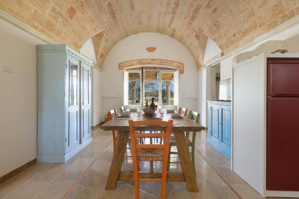 a dining room with a wooden table and chairs at Villa Miliceddu in Tricase