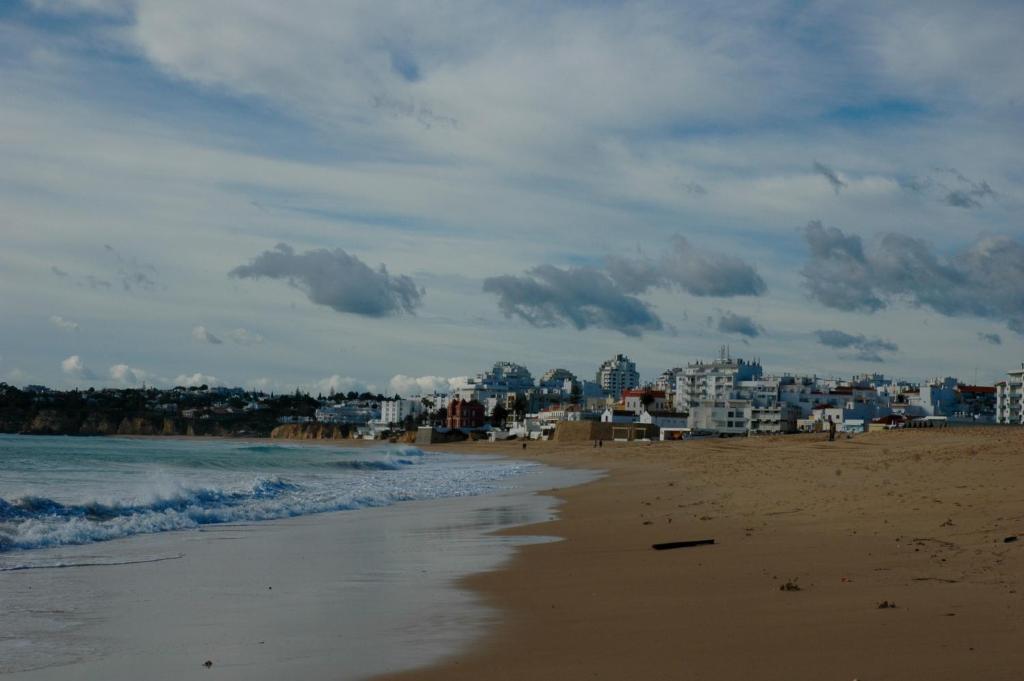 a view of a beach with a city in the background at Edificio Caique C in Armação de Pêra