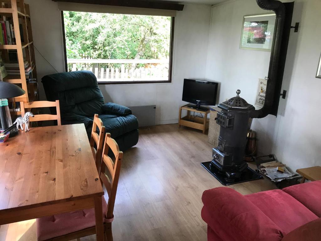 uma sala de estar com uma mesa e um fogão a lenha em Chalet westerham em Winsum