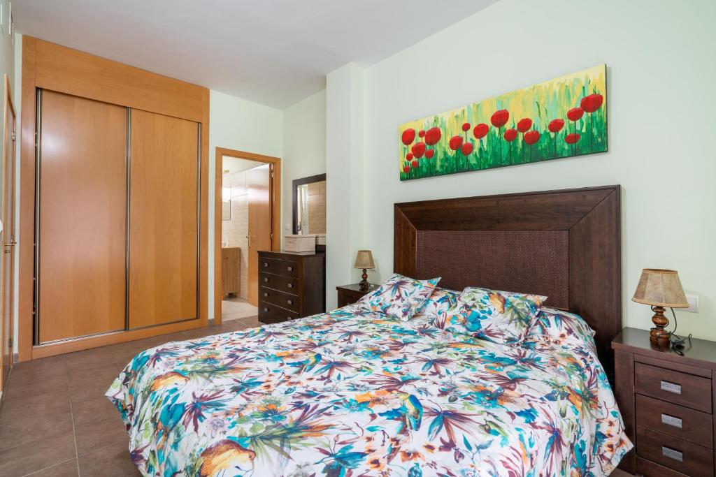 um quarto com uma cama e um quadro na parede em El Rincón de Triana em Almeria