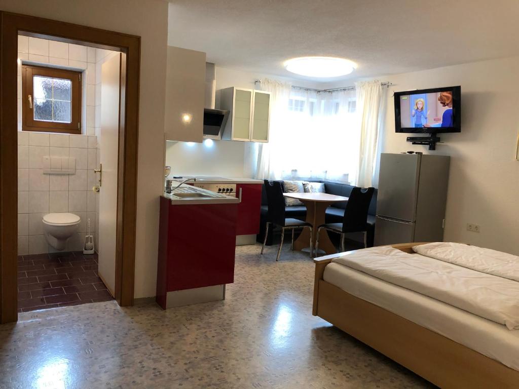 a hotel room with a bed and a kitchen and a table at Ferienwohnung EG Familie Meinschad in Rietz