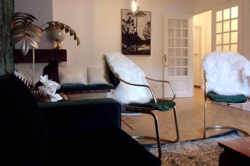 sala de estar con 2 sillas y chimenea en Appartement VILLA PAULA Ax-les-Thermes en Ax-les-Thermes