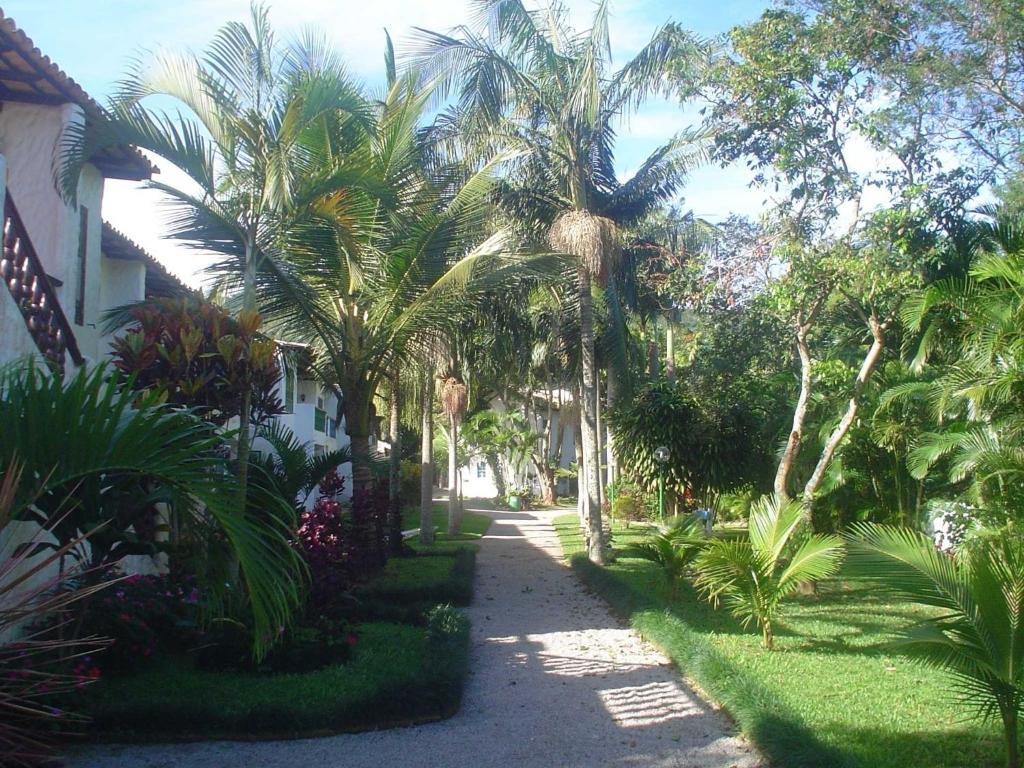 Une promenade avec des palmiers et un bâtiment dans l'établissement Praias Brancas. Boa Vida, à Florianópolis