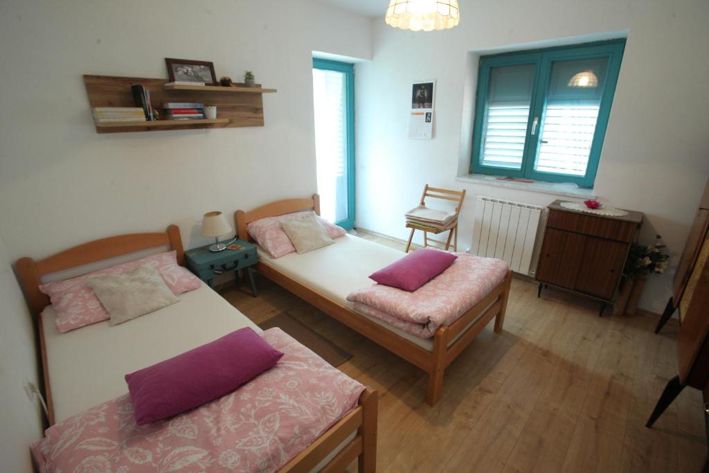 a living room with two beds and a chair at Vila Salamander in Štanjel