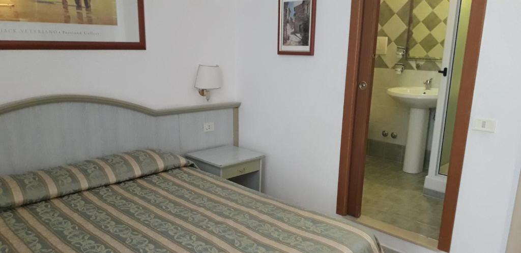 sypialnia z łóżkiem, umywalką i lustrem w obiekcie Gioia Guest House w Rzymie
